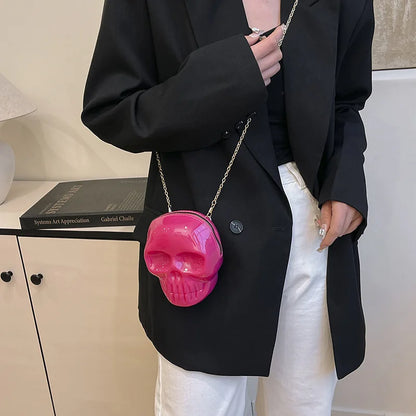 Person wearing a black blazer with a pink skull-shaped handbag.