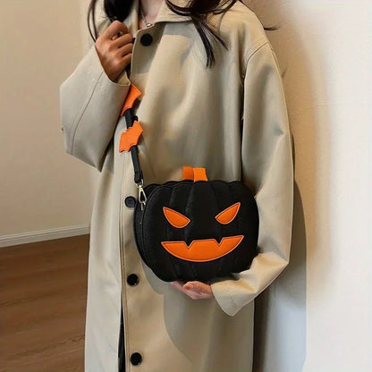 Person holding a black pumpkin-shaped bag with orange details against a neutral background