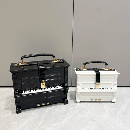 Black and white piano-shaped handbags on a light gray background