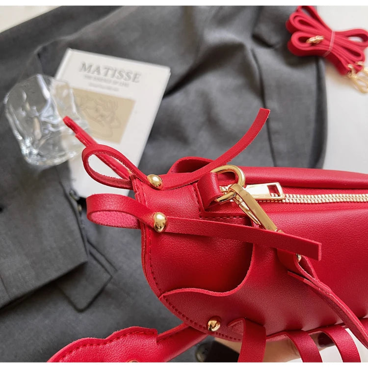 Red handbag with gold accents on a gray surface, featuring the brand 'Matisse'.