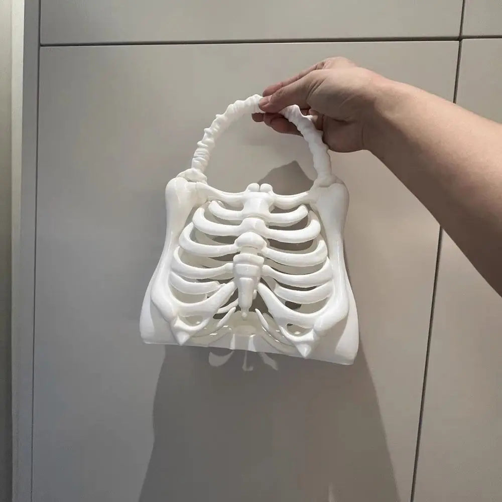 Hand holding a white 3D-printed skeleton model against a neutral background