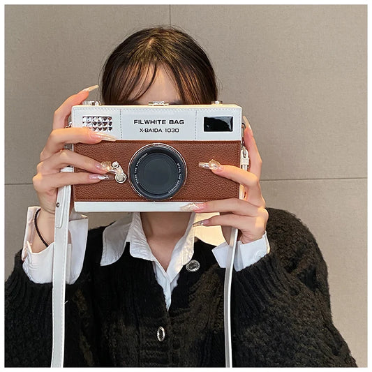 Person holding a retro-style camera with 'FILWHITE BAG' branding against a plain background