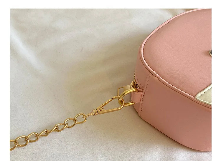 Close-up of a pink handbag corner with a gold chain strap attached via a gold clasp, set against a light fabric background with Chinese text and the English phrase 'THE DETAILS SHOW' in a gray banner at the bottom.